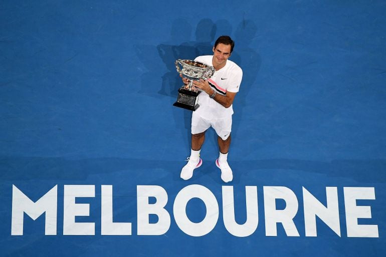 Federer sostiene la copa en la pista