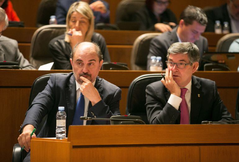 El presidente del Gobierno de Aragón, Javier Lambán y el consejero de Presidencia, Vicente Guillén escuchan la intervención de uno de los portavoces parlamentarios, durante la segunda sesión del debate sobre el estado de la comunidad en las Cortes de Ar