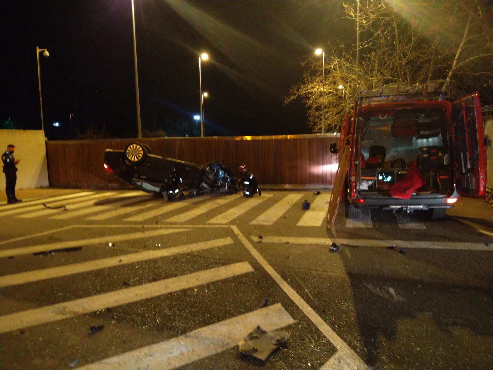 Los bomberos inspeccionan el vehículo siniestrado