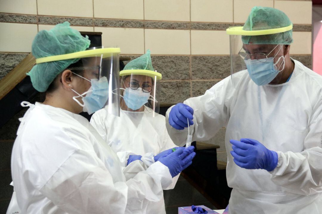 Personal sanitario con muestras de PCR.