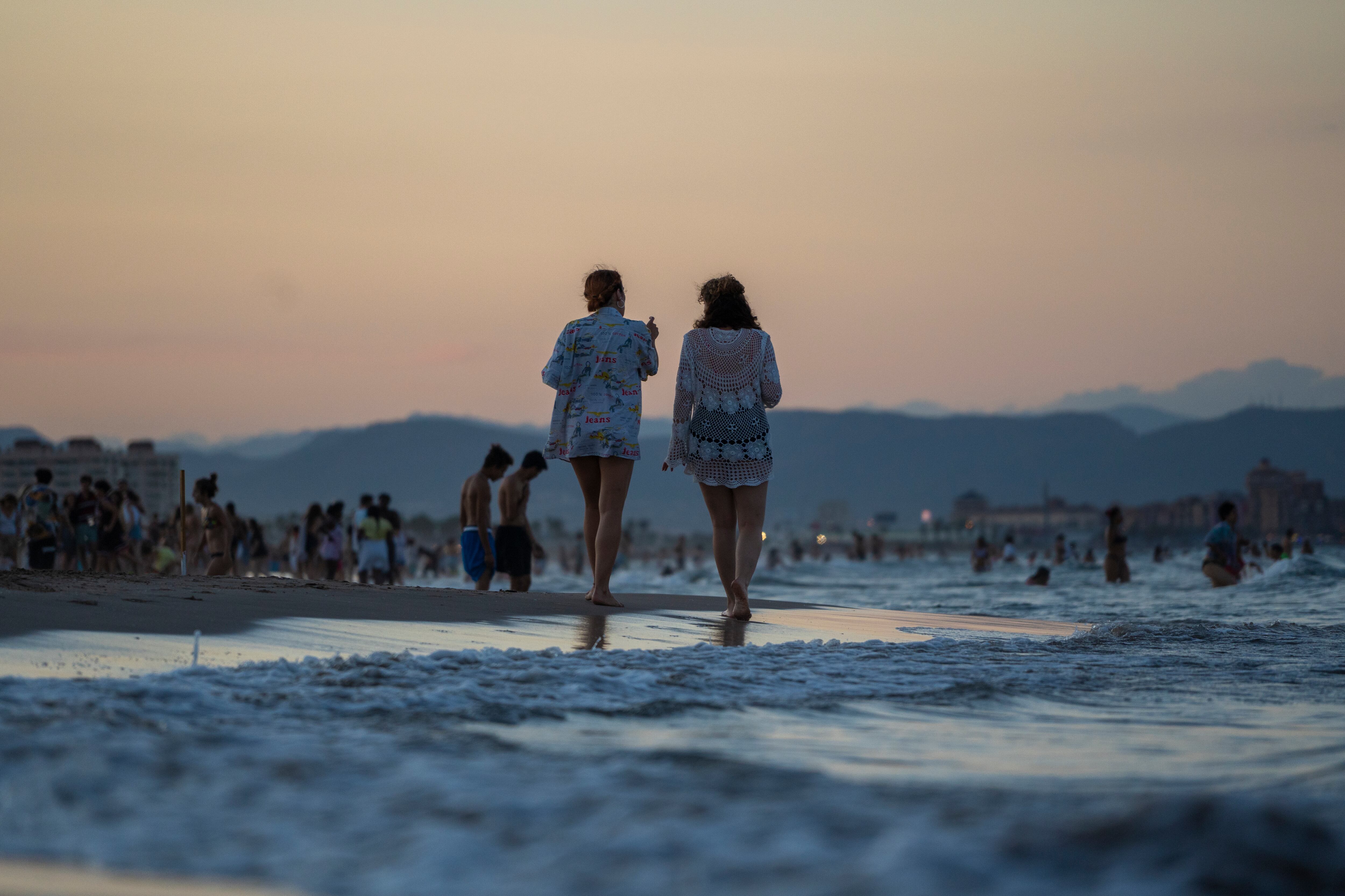 Dos personas pasean por una playa de València en una imagen de archivo.