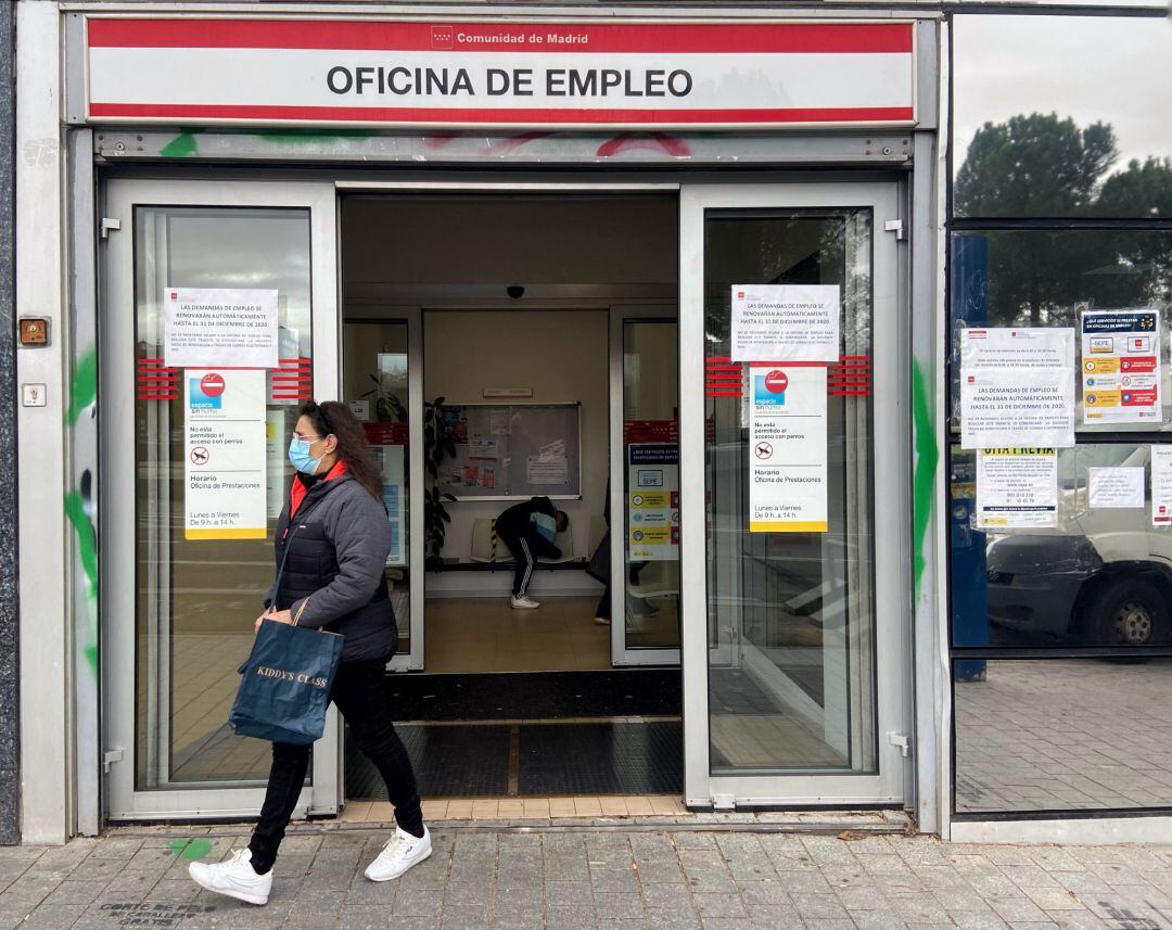 Una mujer sale de una oficina de empleo