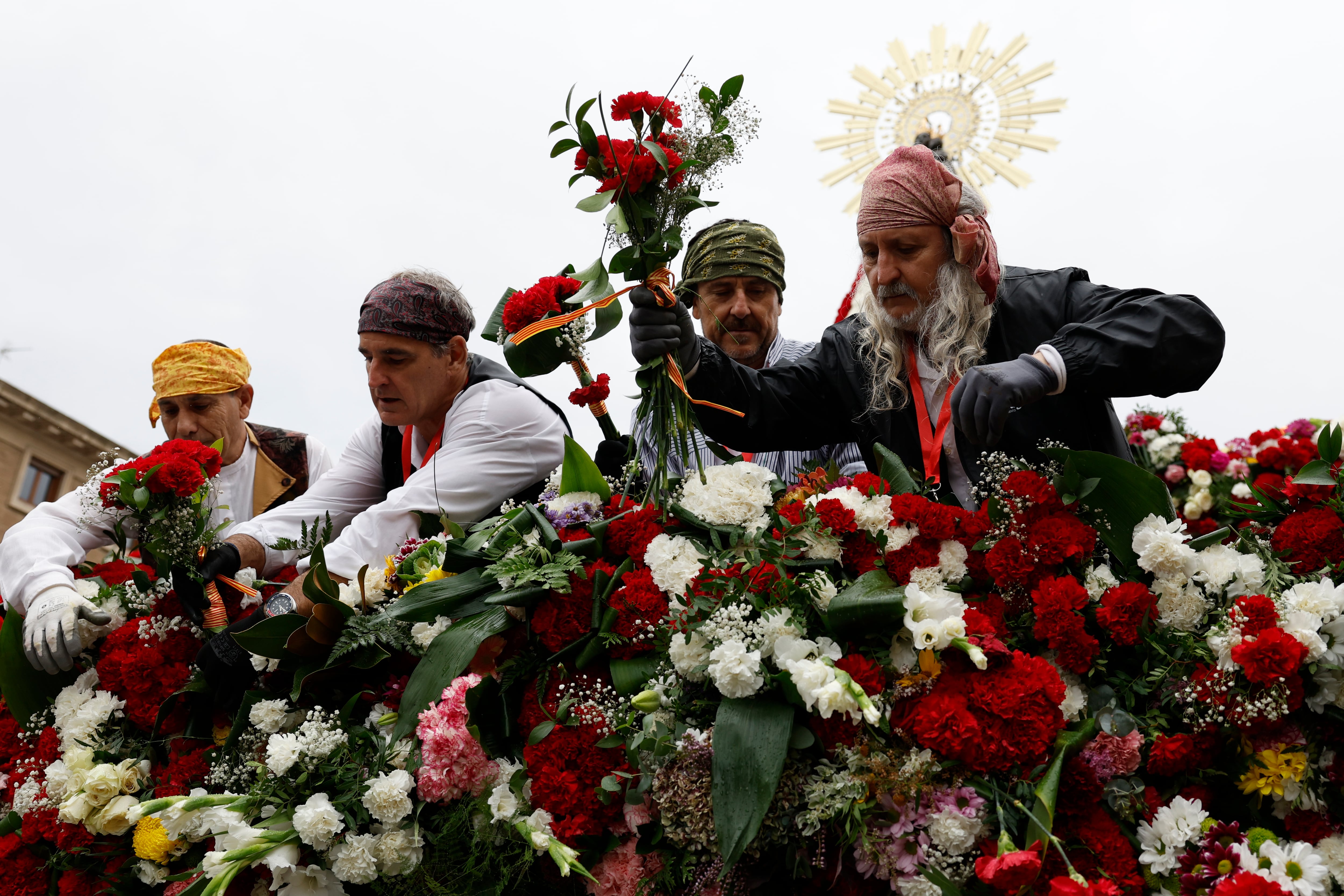 -FOTODELDÍA- ZARAGOZA, 12/10/2024.- Varias personas colocan las flores a los pies de la Virgen del Pilar durante la tradicional Ofrenda de Flores a la Virgen este sábado en Zaragoza. EFE/Javier Cebollada
