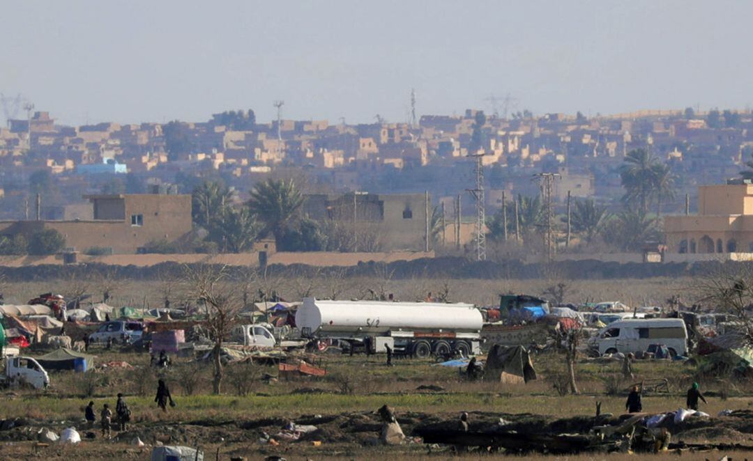 Islamic state members walk in the last besieged neighborhood in the village of Baghouz, Deir Al Zor province, Syria February 18, 2019. REUTERS