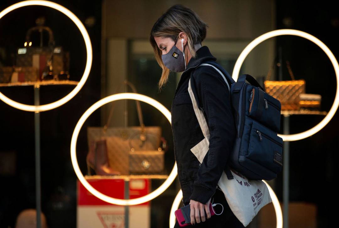 Una vecina andando por la calle con mascarilla.