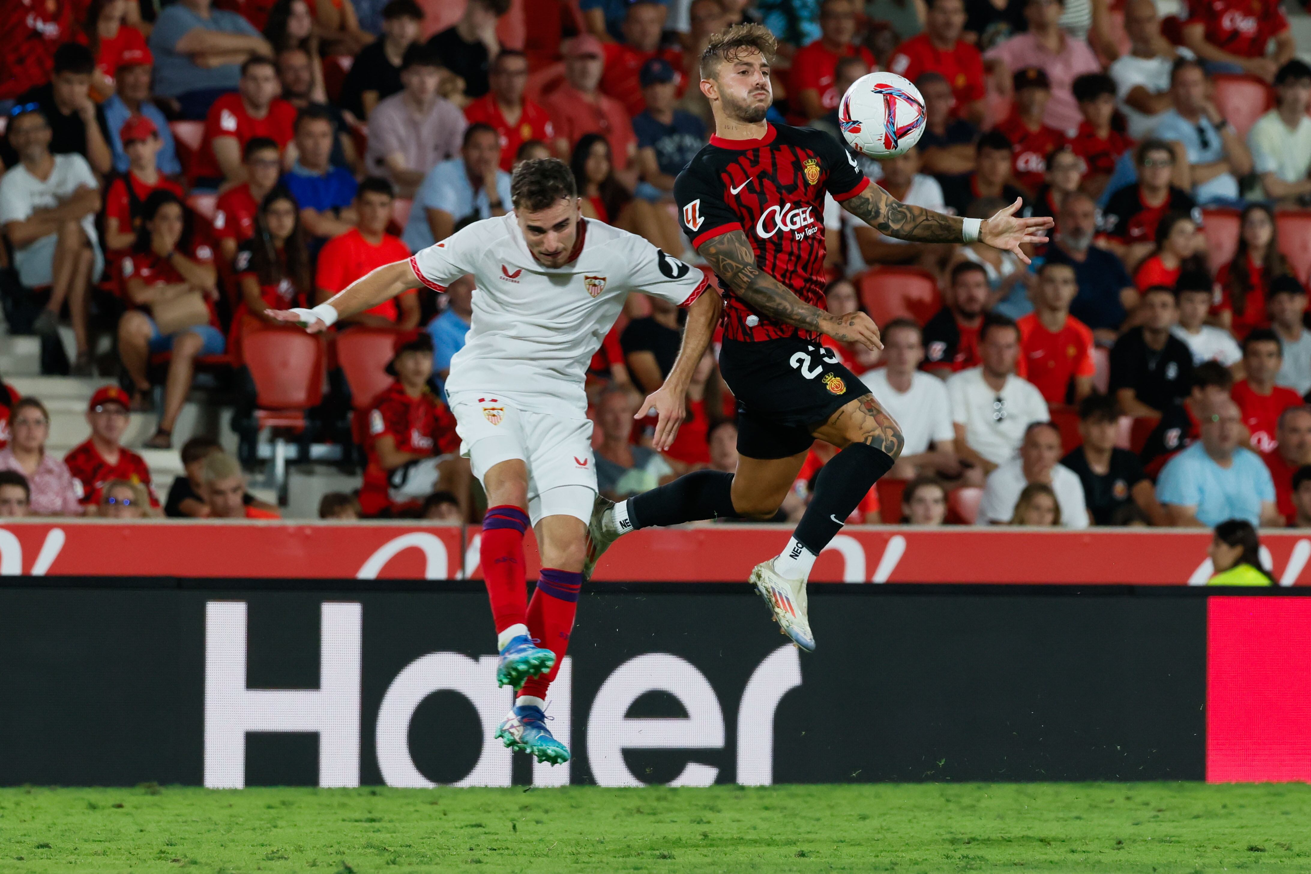 PALMA , 27/08/2024.-  El defensa del Mallorca Pablo Maffeo (d) pelea un balón con el defensa del Sevilla Adriá Pedrosa durante el partido de LaLiga entre el Mallorca y el Sevilla, este martes en el estadio de Son Moix. EFE/CATI CLADERA
