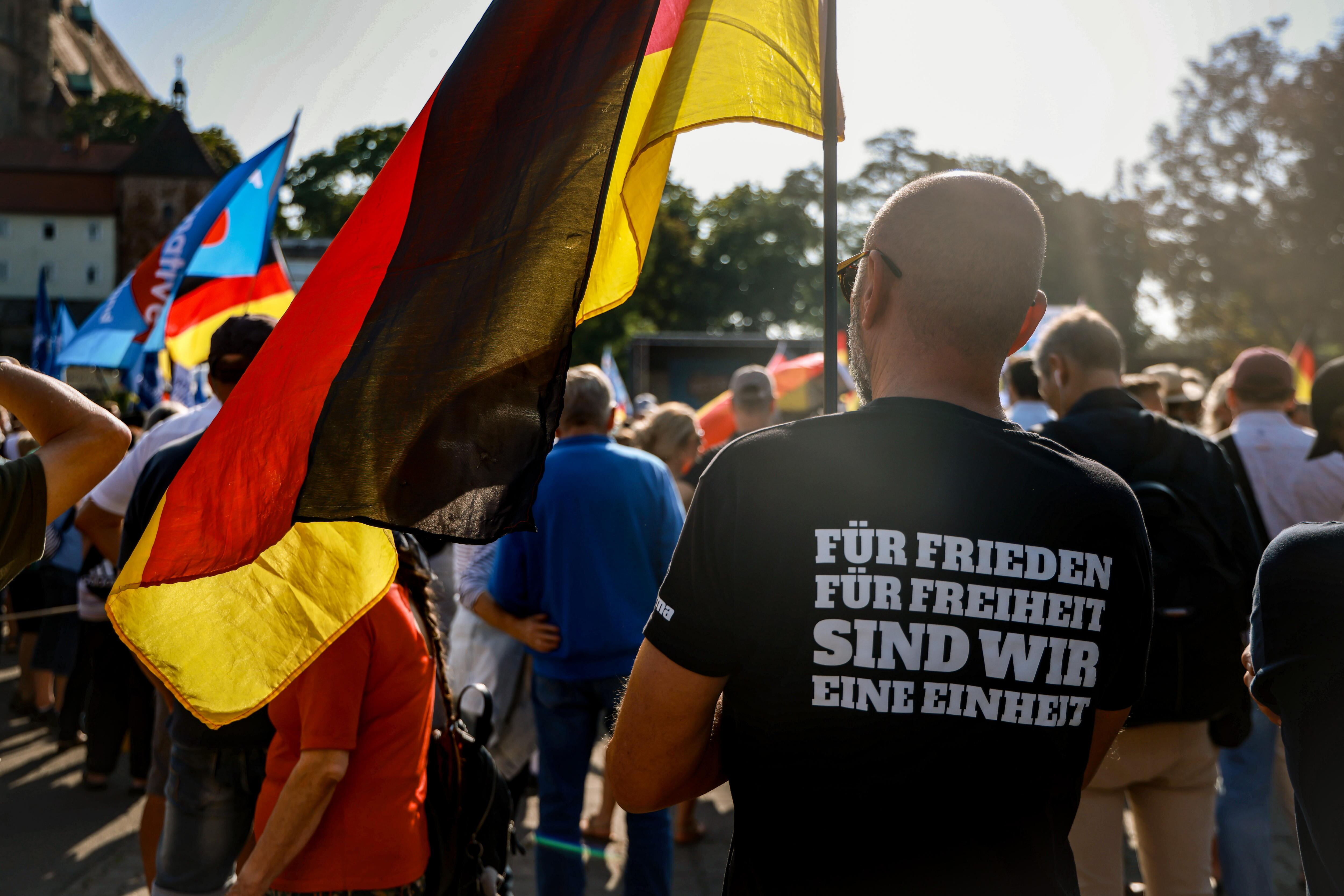 Partidarios de Alternativa para Alemania esperan al inicio de un mitin en Turingia antes de las elecciones. En la camiseta puede leerse &quot;para la paz, para la libertad, somos uno&quot;