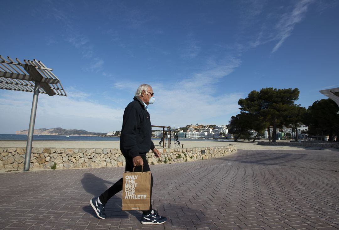 Un señor con una mascarilla en el paseo marítimo de Calviá (Mallorca)