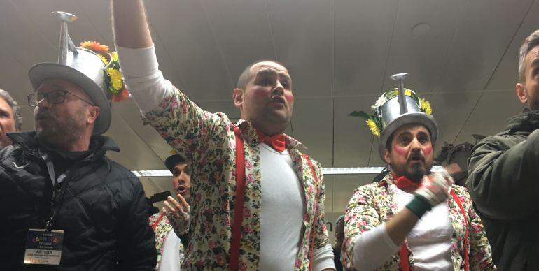 Juan Carlos Cruz, promotor de la comparsa Los Primavera, canta en la estación de Sants con componentes del coro de Julio Pardo