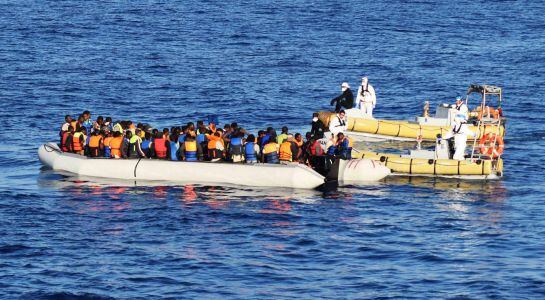 Varios miembros del ejército italiano mientras ayudan a decenas de inmigrantes durante una operación de rescate en el mar Mediterráneo, cerca de la costa de Libia.