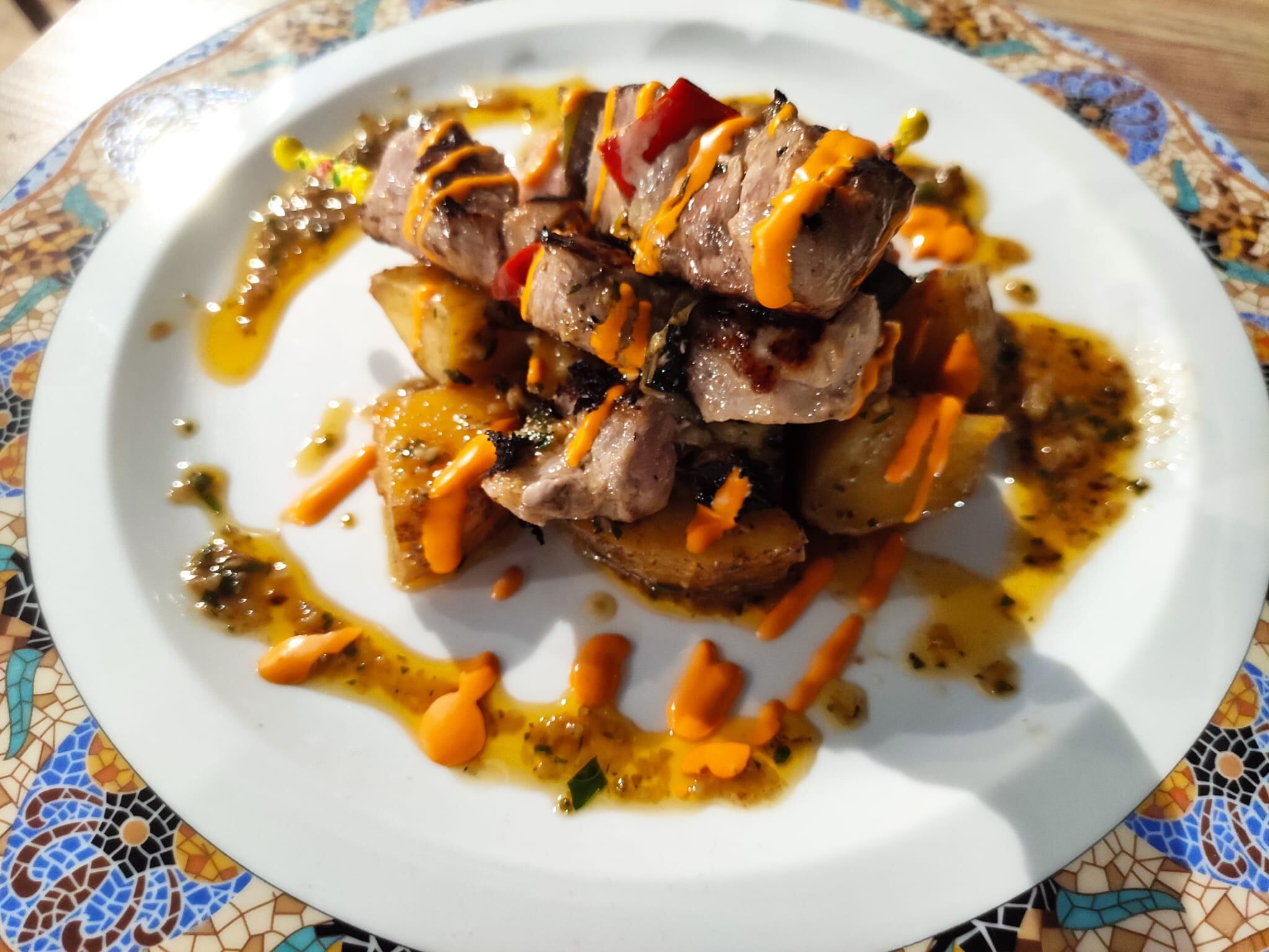 Mini brochetas de solomillo sobre papitas locas y mojo rojo