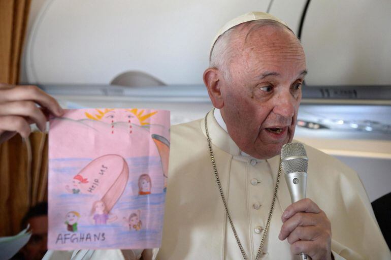 El Papa Francisco muestra un dibujo elaborado por un niño en el campamento de Moria durante el vuelo de regreso hasta Roma