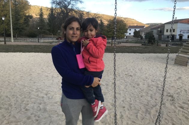 Andrea, con su hija, en los columpios del parque.