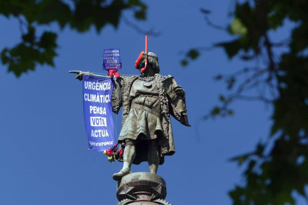 Dos activistas de la organización ecologista Greenpeace han colocado este sábado unas gafas de buzo a la estatua de Colón, ubicada al final de la Rambla de Barcelona, para alertar de que el cambio climático en la Tierra 