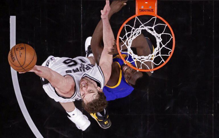 El jugador de los Spurs de San Antonio, Pau Gasol entra a canasta a pesar de la defensa de Draymond Green, de los Warriors de Golden State.