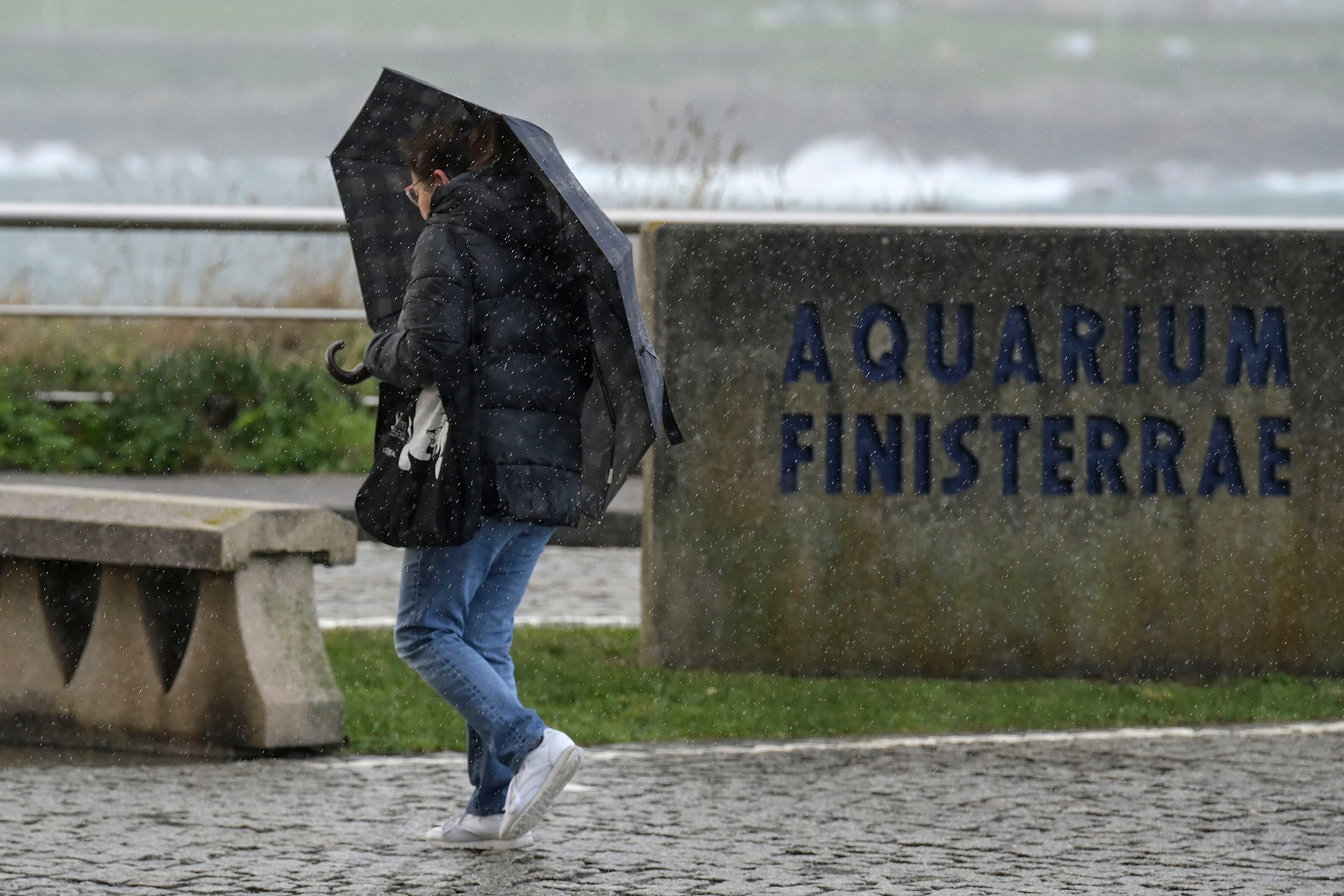 Una persona se protege de la lluvia por el paseo marítimo con la entrada de la borrasca Goretti en Galicia el 9 de enero de 2026.