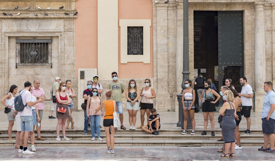 Un grupo de turistas en la plaza de la Virgen de València. 