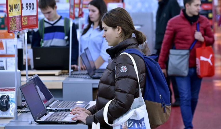 Una mujer prueba un ordenador portátil en una tienda