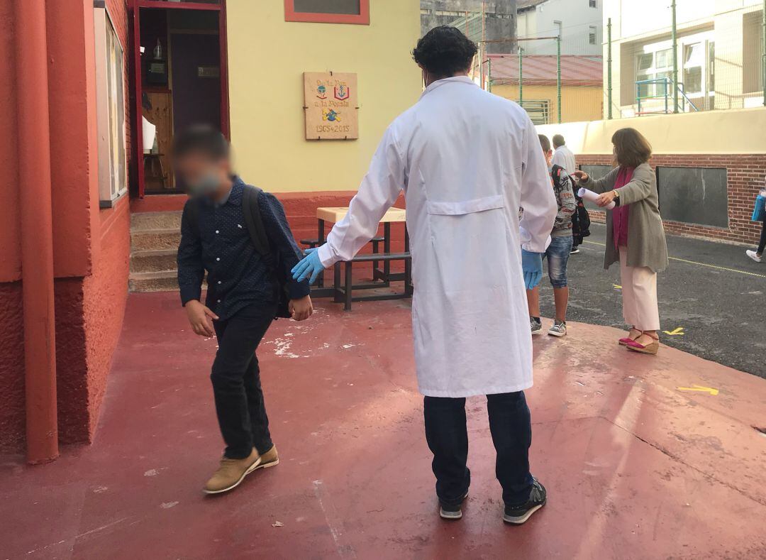 Un niño entra en el colegio tras tomarse la temperatura.