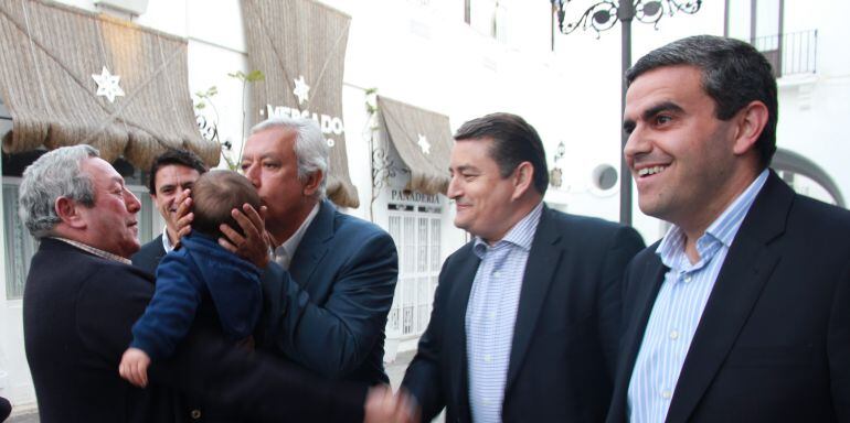 Imagen de Antonio Sanz (izq) y José Ortiz (derecha), junto a Javier Arenas, quien besa a un niño en Vejer