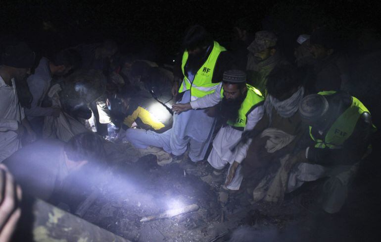 Miembros de los equipos de rescate buscan los cuerpos de las víctimas del avión de la compañía Pakistán International Airlines.