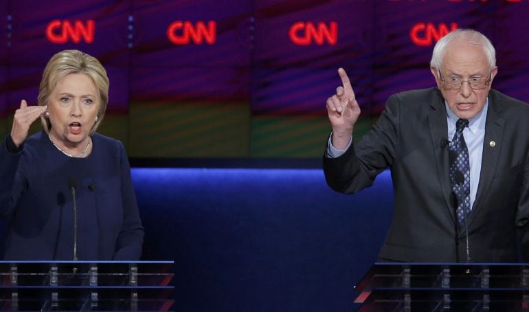 Democratic U.S. presidential candidate Hillary Clinton and rival Bernie Sanders speak simultaneously during the Democratic U.S. presidential candidates&#039; debate in Flint, Michigan, March 6, 2016. REUTERS-Jim Young 