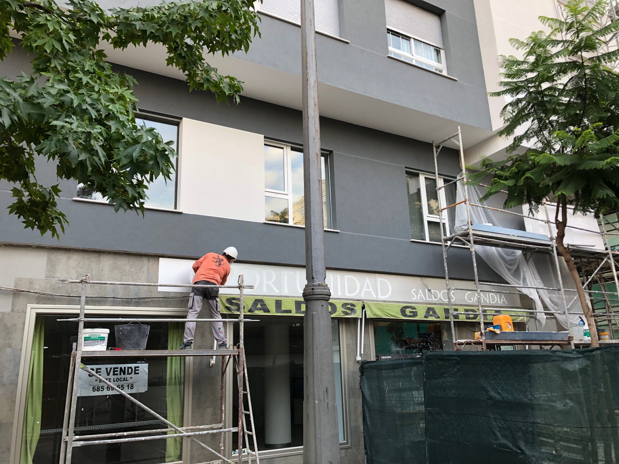 Trabajadores en las obras de reforma de la fachada de un edificio en Gandia