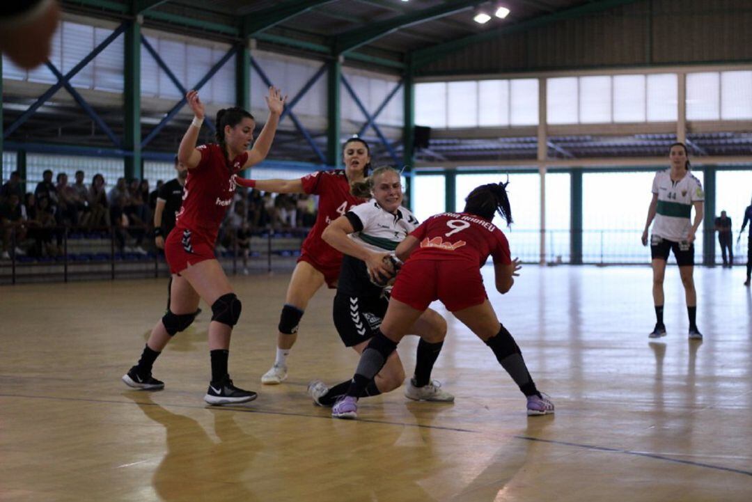 La jugadora del Elche pugna rodeada por tres rivales