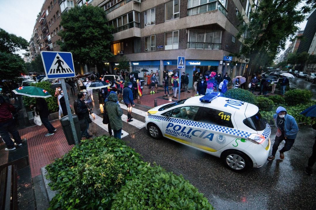 Varias personas se colocan delante de una patrulla de Policía Municipal en señal de protesta durante una concentración de vecinos en el barrio Salamanca (Madrid)