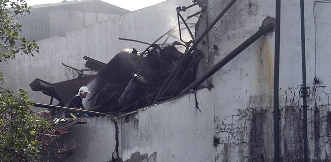 Un miembro del cuerpo de bomberos entre los restos de la almazara de la Moraleja (Cáceres), donde se ha registrado una explosión que ha causado al menos dos muertos y dos heridos, y otra persona se encuentran desaparecida