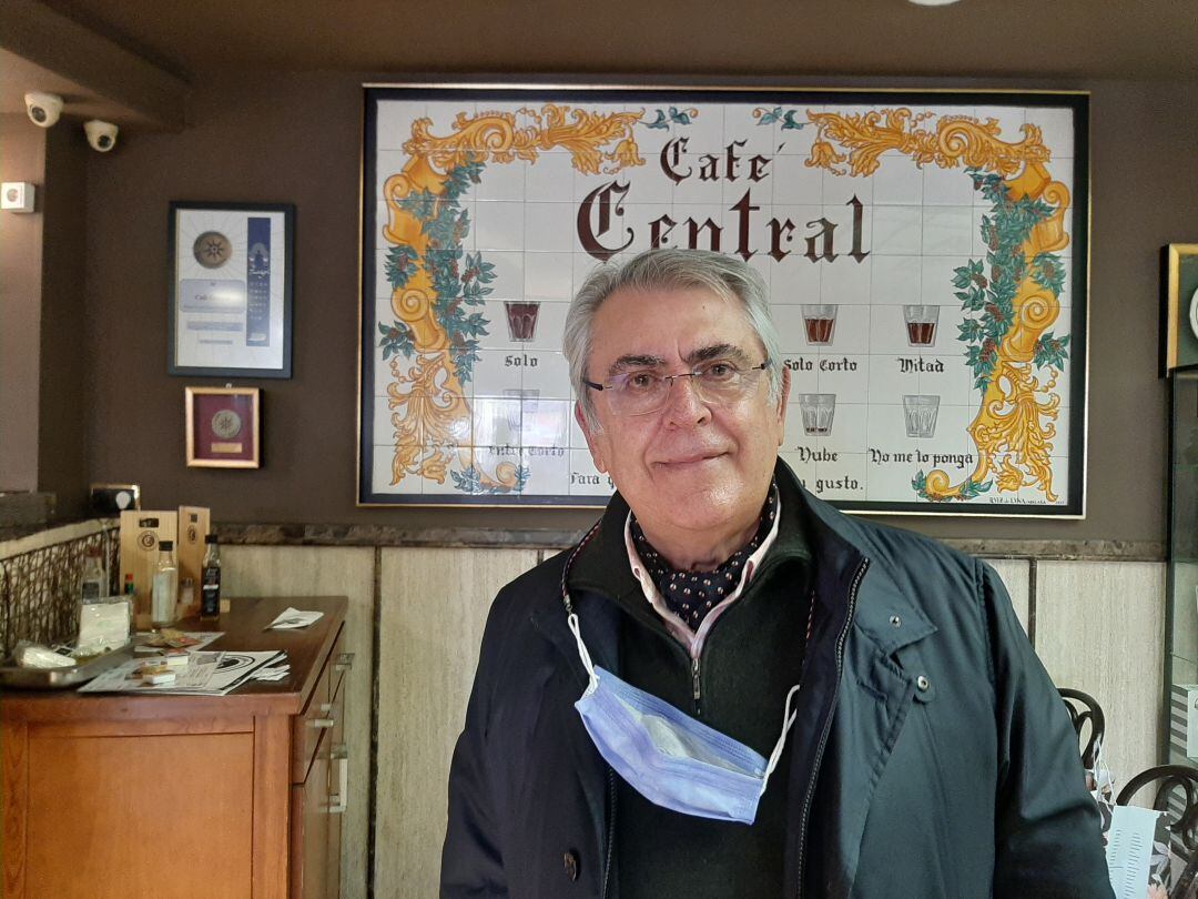 Rafael Prado posa junto a uno de los azulejos donde se explica las distintas maneras de pedir un café en Málaga