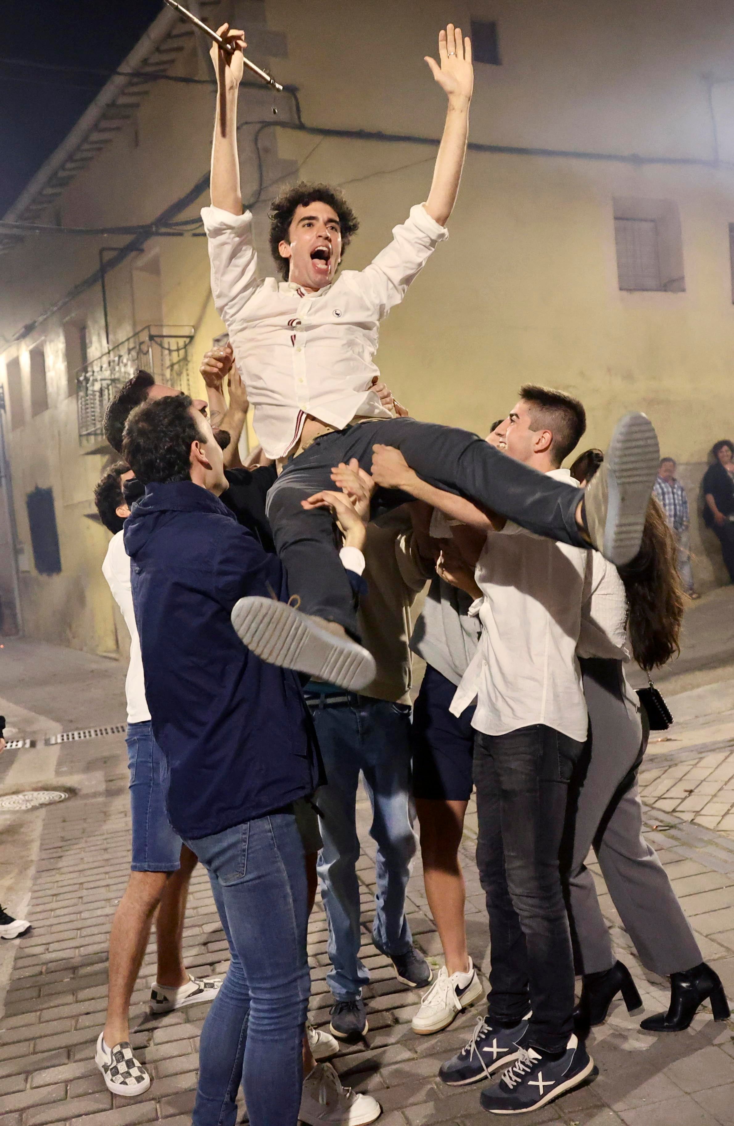 SAN MILLÁN DE LA COGOLLA (LA RIOJA), 17/06/2023.- Ismael Maestro, el candidato municipal más joven de La Rioja, es manteado por los vecinos tras ser el primero en tomar posesión de su cargo como alcalde de San Millán de la Cogolla, apenas un minuto pasada la medianoche de este viernes, para garantizar a sus vecinos el disfrute en la tradicional romería a la ermita del santo que se celebra el sábado. EFE/Raquel Manzanares
