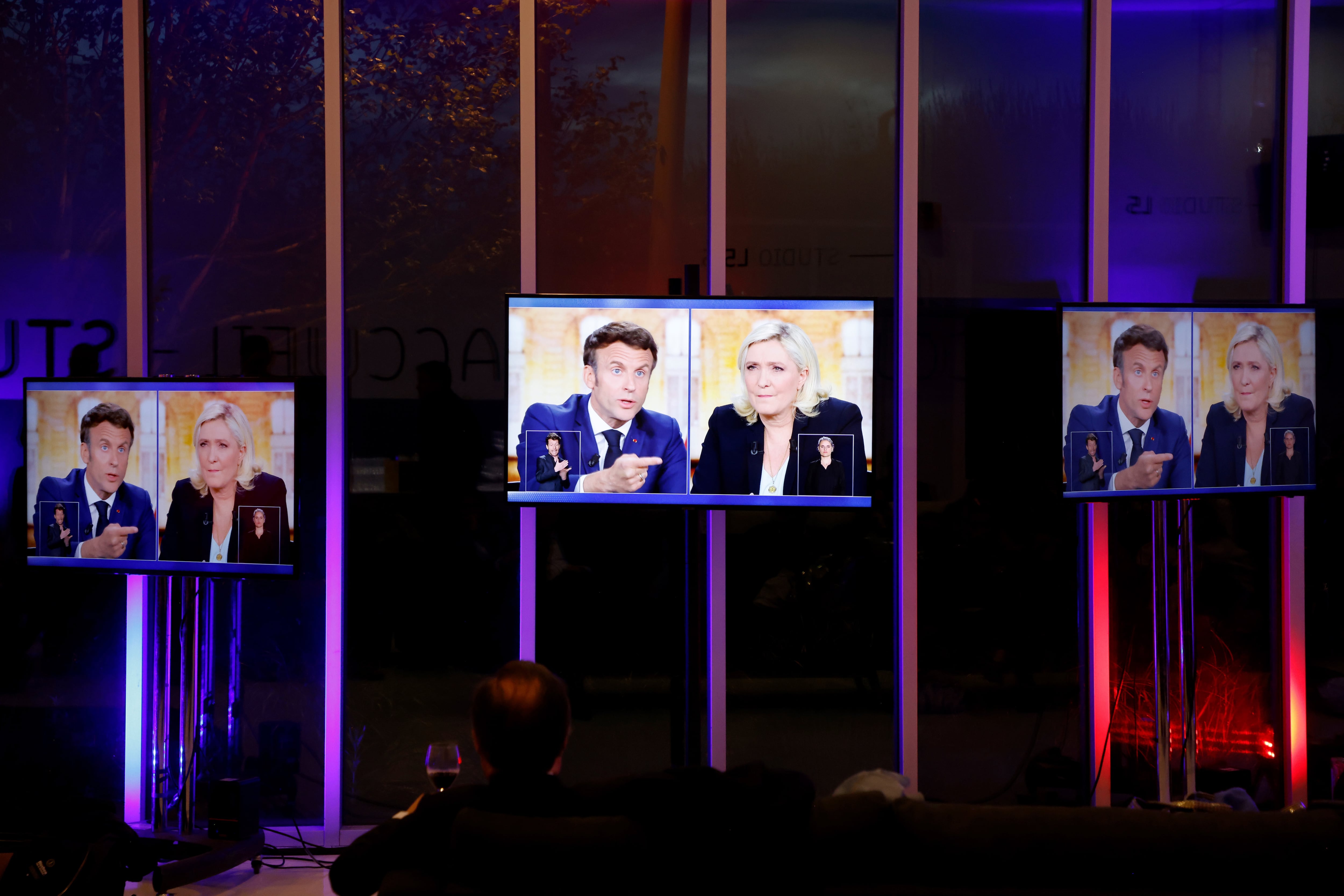 Varias pantallas muestran el debate entre Macron y Le Pen.