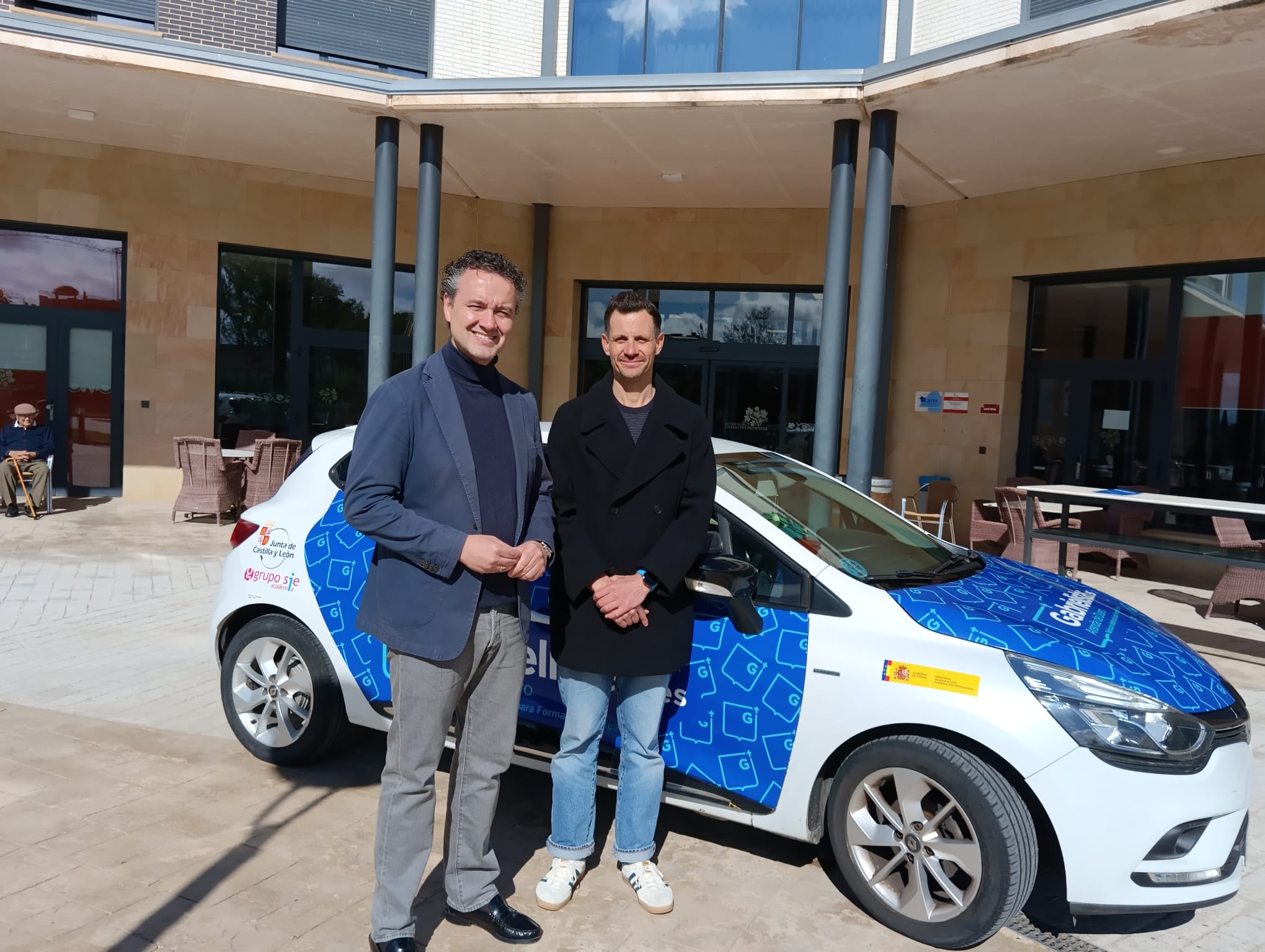 Enrique García Aguera (izq) y Eduardo Losantos posan ante el vehículo de prácticas para los futuros profesores
