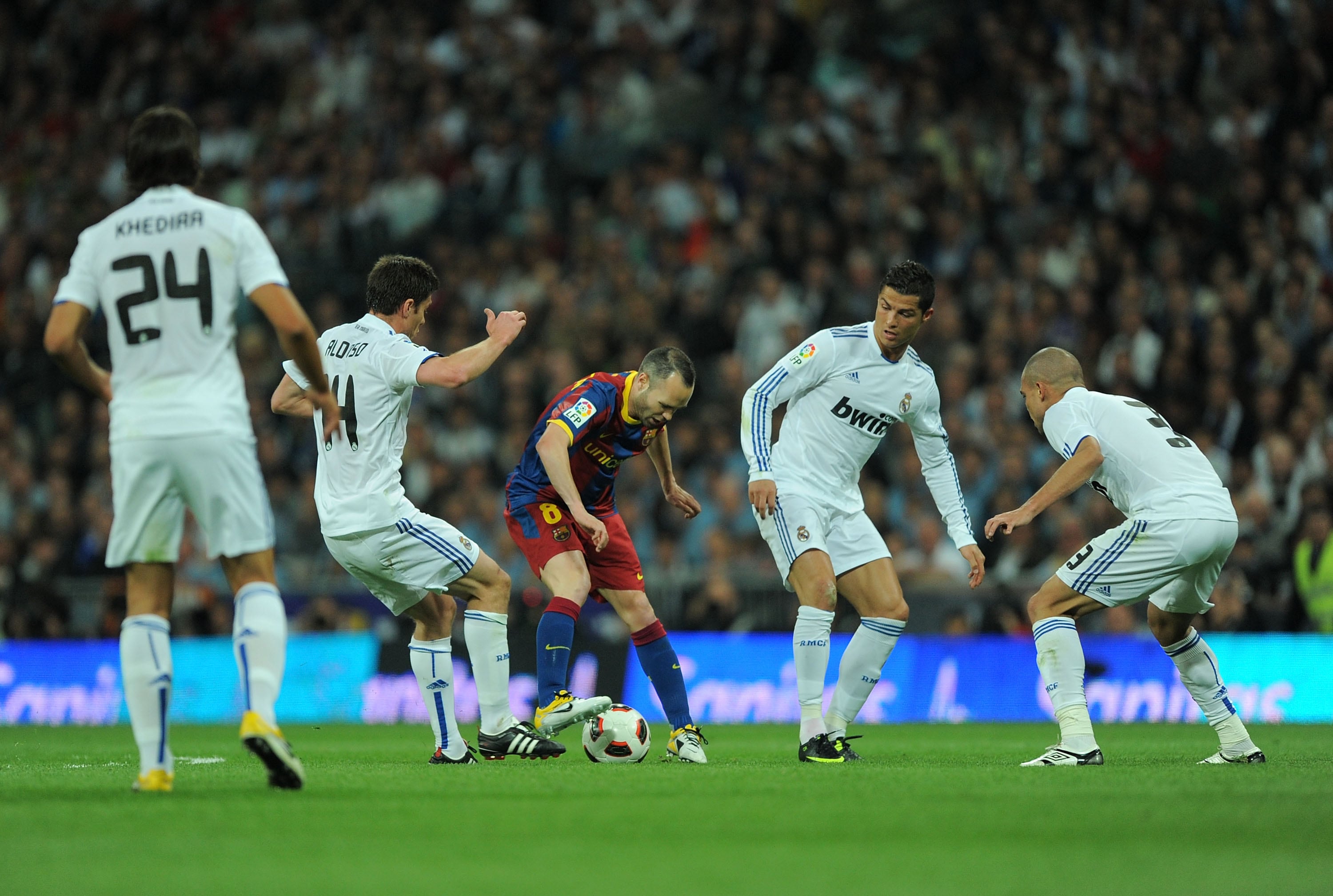 Andrés Iniesta rodeado de jugadores del Real Madrid