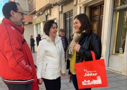 La alcaldesa M.ª Teresa García, a la derecha, conversa con unos vecinos en la primera jornada de reparto, portando una de las bolsas de compra