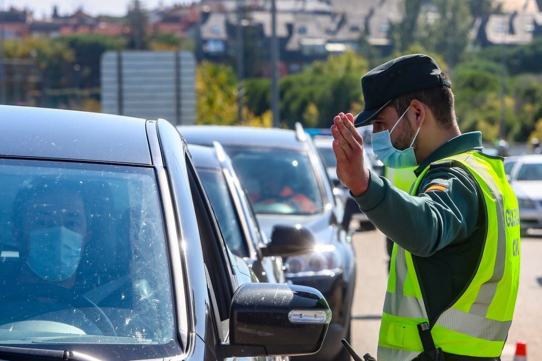 Un agente de la Guardia Civil da el alto a un vehículo durante un control