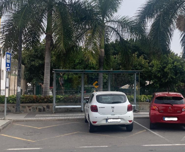 L apoca frecuencia y el poco uso de las guaguas fomenta situaciones como esta, con coches aparcados en plena parada