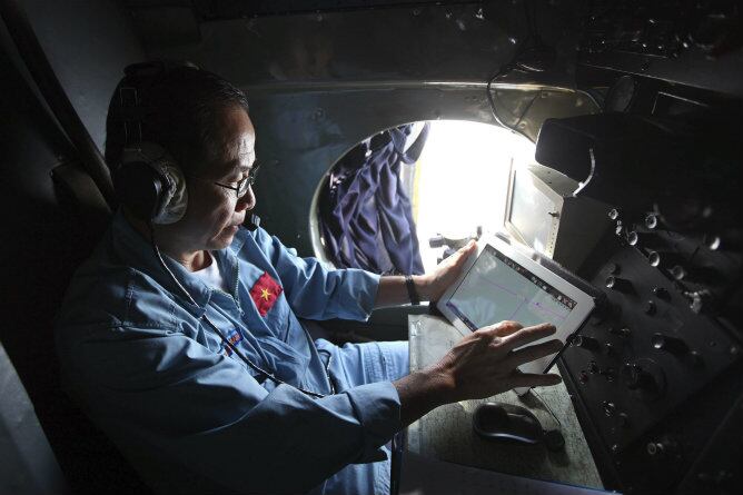 Un oficial trabaja desde un avión de las Fuerzas Armadas de Vietnam durante la operación de búsqueda del vuelo de Malaysia Airlines