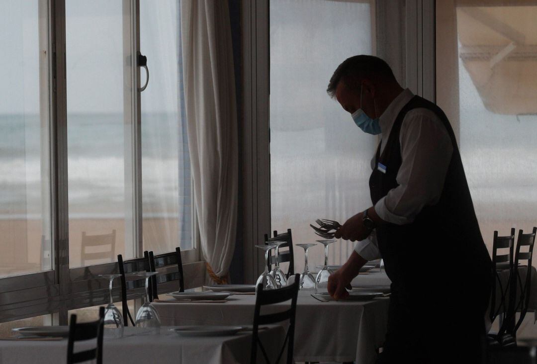 Imagen de archivo de un camarero prepara una mesa en el interior de un restaurante.
