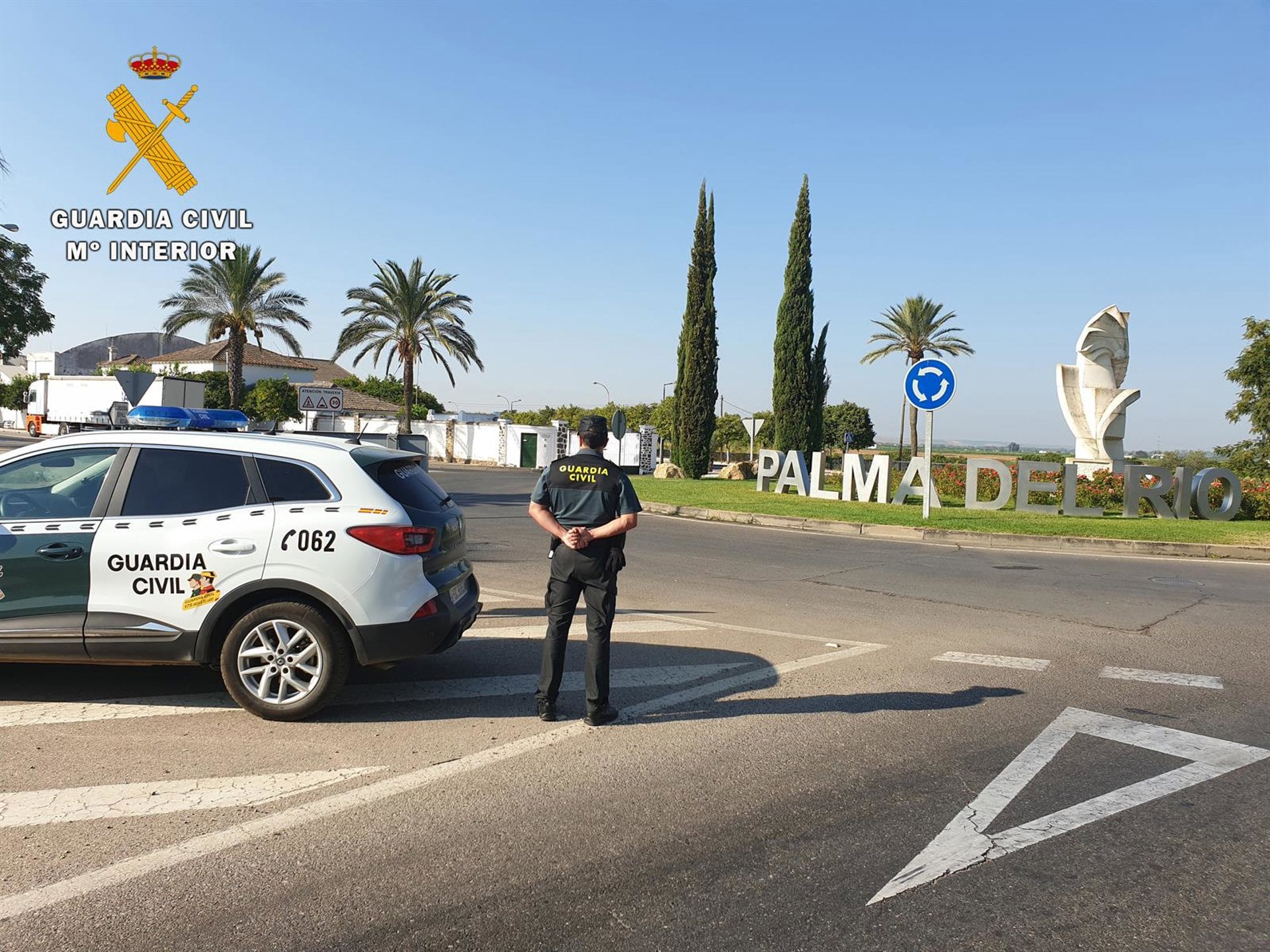 Un guardia civil, junto a su coche patrulla, en uno de los accesos a Palma del Rio (EP)