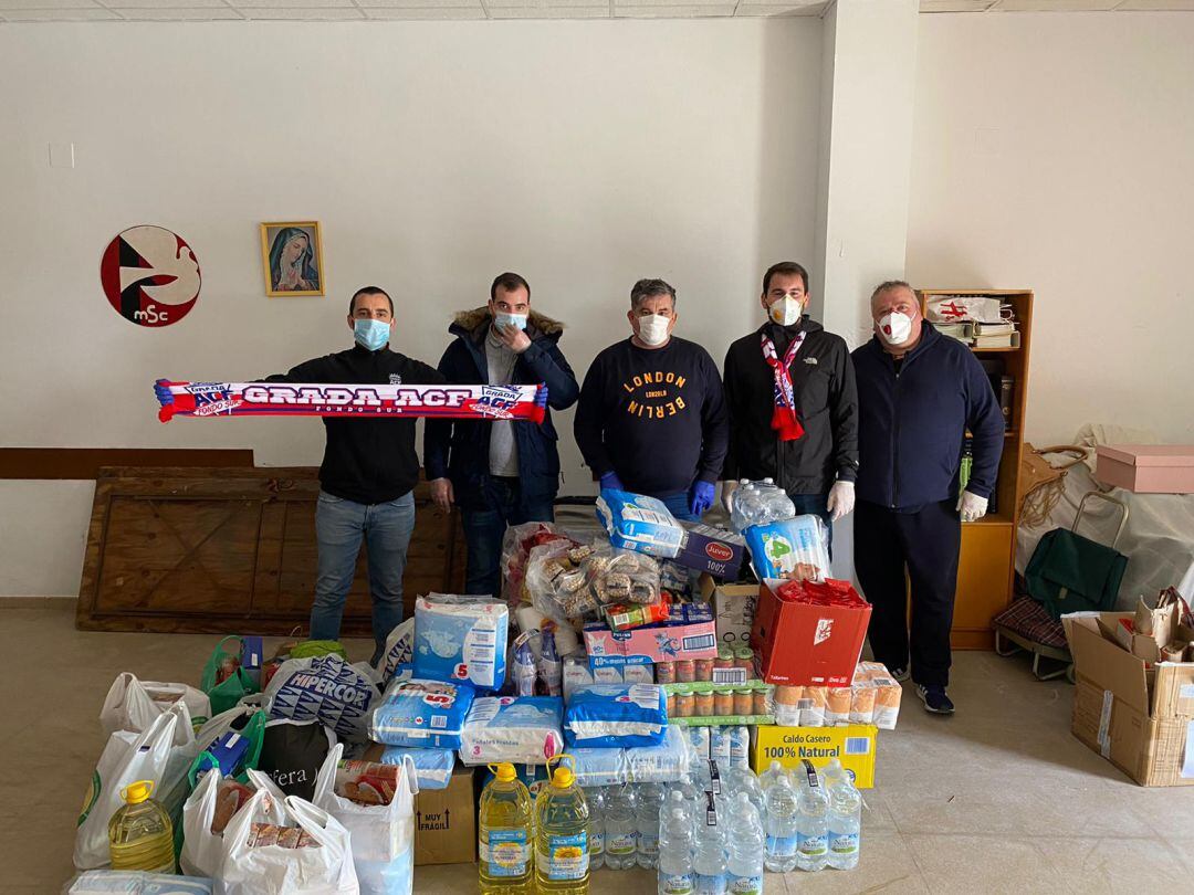 Miembros de la peña entregan los alimentos.