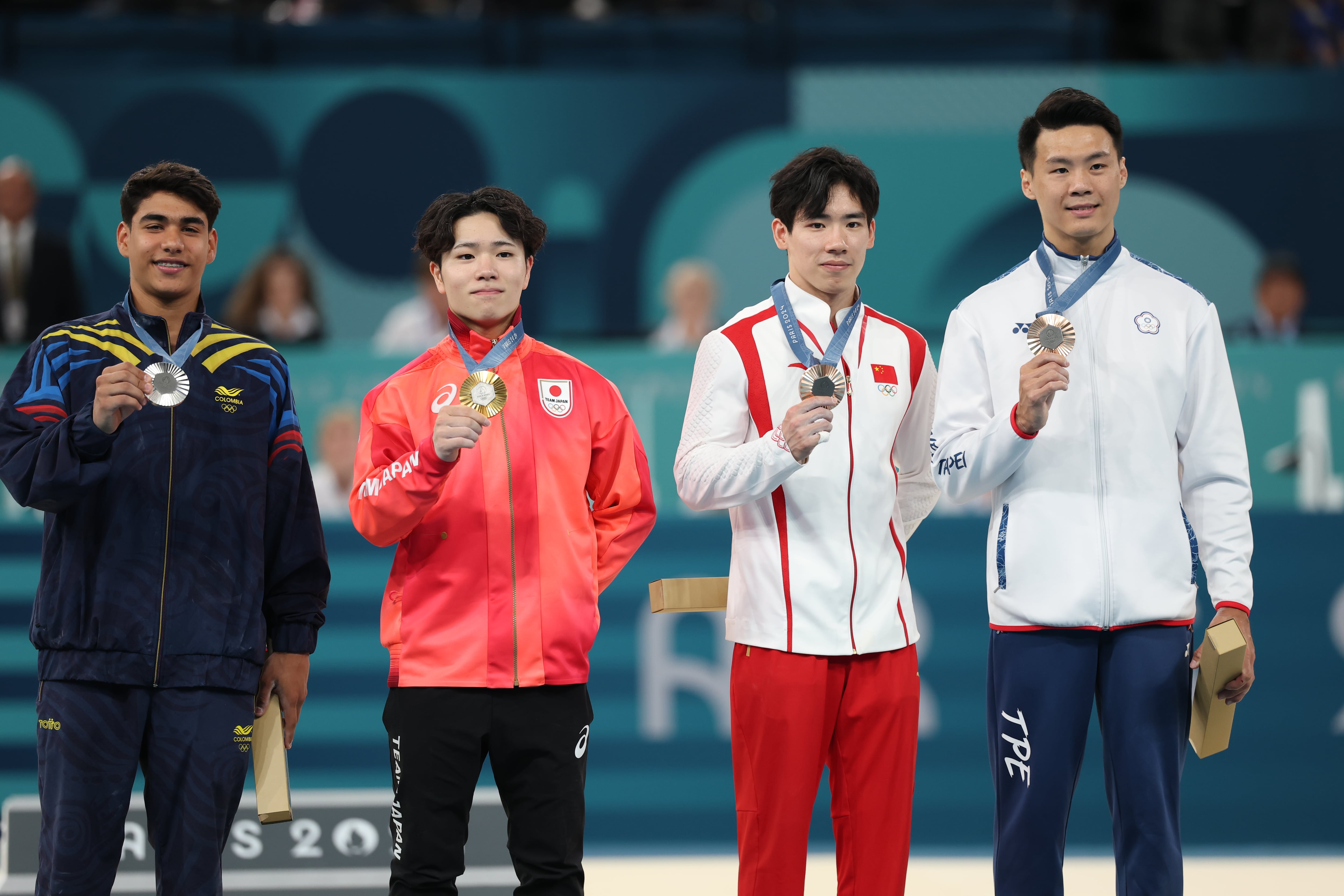 Entrega de medallas en gimnasia en los Juegos de París con la presencia del chino Boheng Zhang y del representante taiwanés Chia-Hung Tang