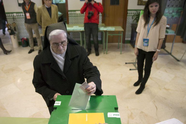 Una monja introduce su voto en las elecciones autonómicas para la Junta de Andalucía.