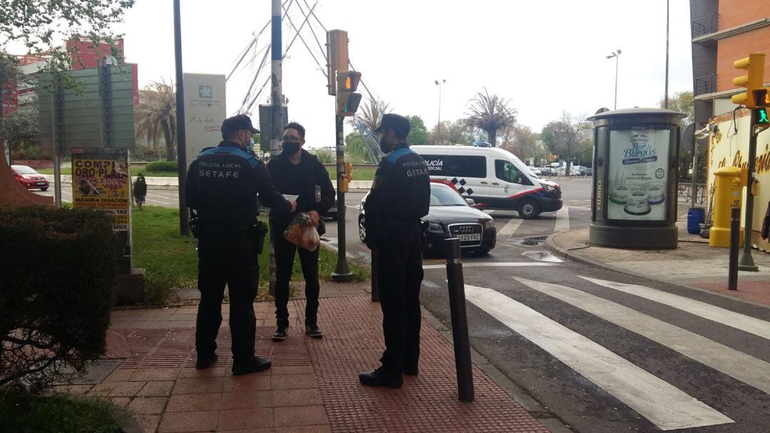 Dos policías locales de Getafe informan a un vecino de las restricciones en la ZBS de Las Margaritas, que mantiene esas medidas, al menos, hasta el domingo.