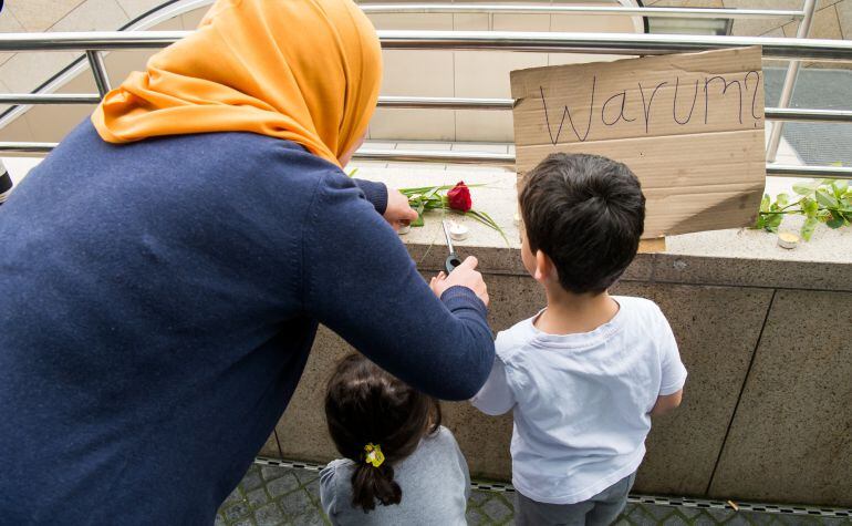 Una mujer y sus hijos dejan flores en el lugar del ataque