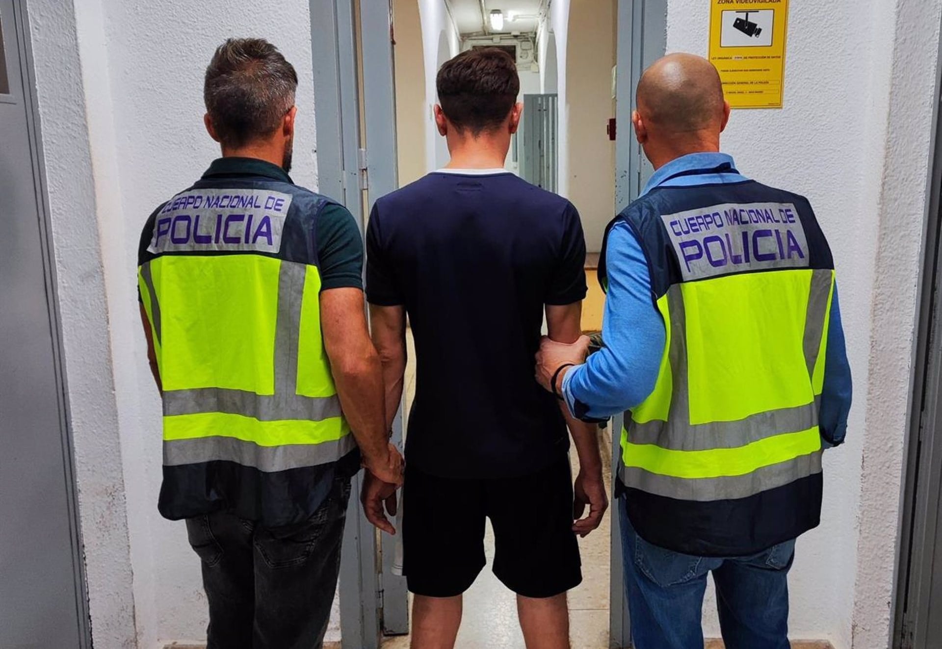 El detenido custodiado por dos agentes