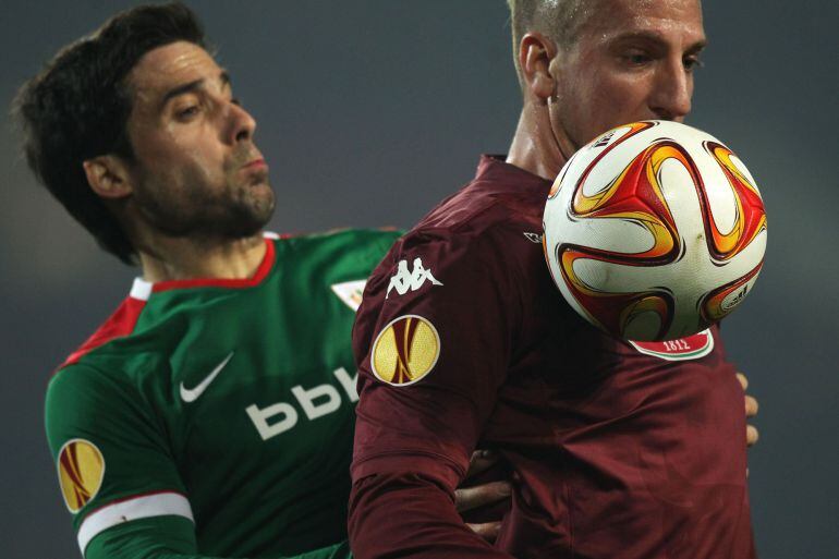 Athletic Bilbao&#039;s Spanish defender Xabier Etxeita Gorritxategi (L) fights for the ball with Torino&#039;s Argentinian forward Maxi Lopez during the UEFA Europe League round of 32 football match Torino Vs Athletic Bilbao on February 19, 2015 at the &quot;Olympic Stadium&quot; in Turin.  AFP PHOTO / MARCO BERTORELLO