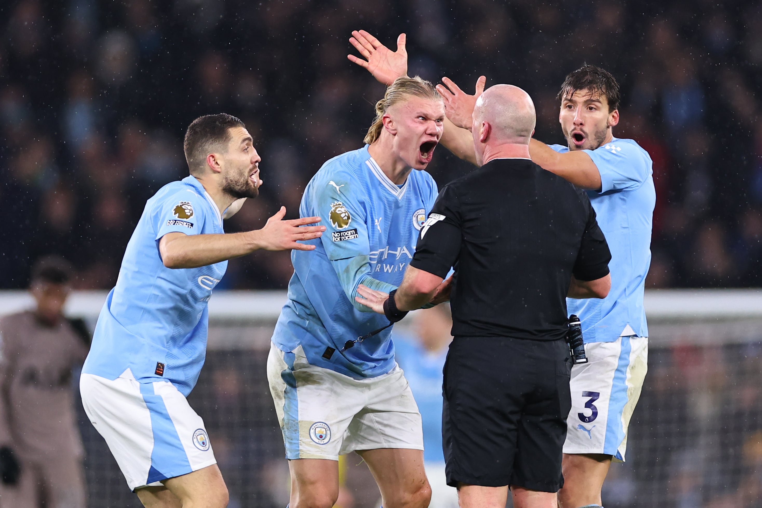 Jugadores del Manchester City protestan airosamente a Simon Hooper, colegiado del encuentro.