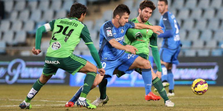 El delantero del Getafe Pablo Sarabia (c) lucha un balón con los jugadores del Celta, Sergi Gómez (d) y el argentino Augusto Fernández (i), durante el partido de la jornada vigésima de la Liga de Primera División, que se juega hoy en el Coliseum Alfonso P